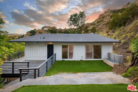 an aerial view of a house with yard and green space