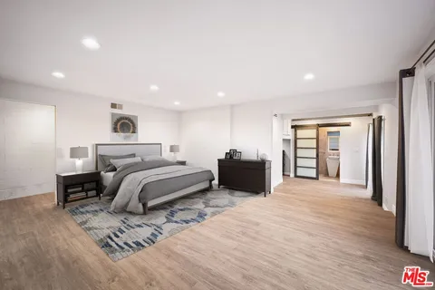 a spacious bedroom with a bed a table and a dresser