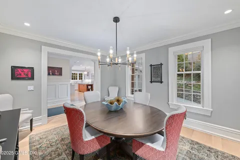 a living room with stainless steel appliances granite countertop furniture dining table and a wooden floor