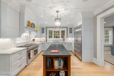 a kitchen with kitchen island a sink stove and refrigerator