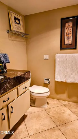 a bathroom with a granite countertop sink and a toilet