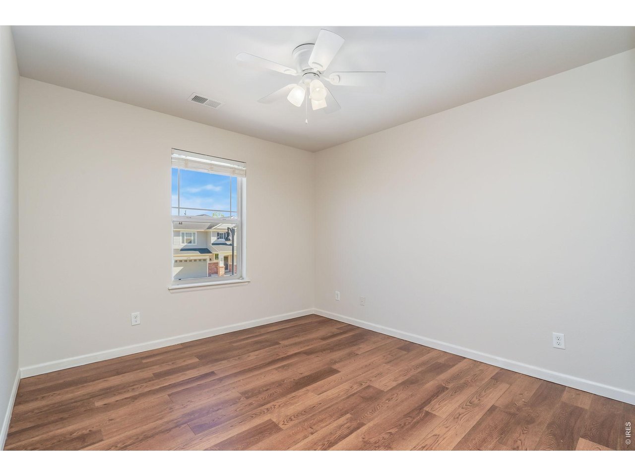 6759 Rainier Road Timnath, CO 80547 - Photo 19 of 30 an empty room with wooden floor and ceiling fan