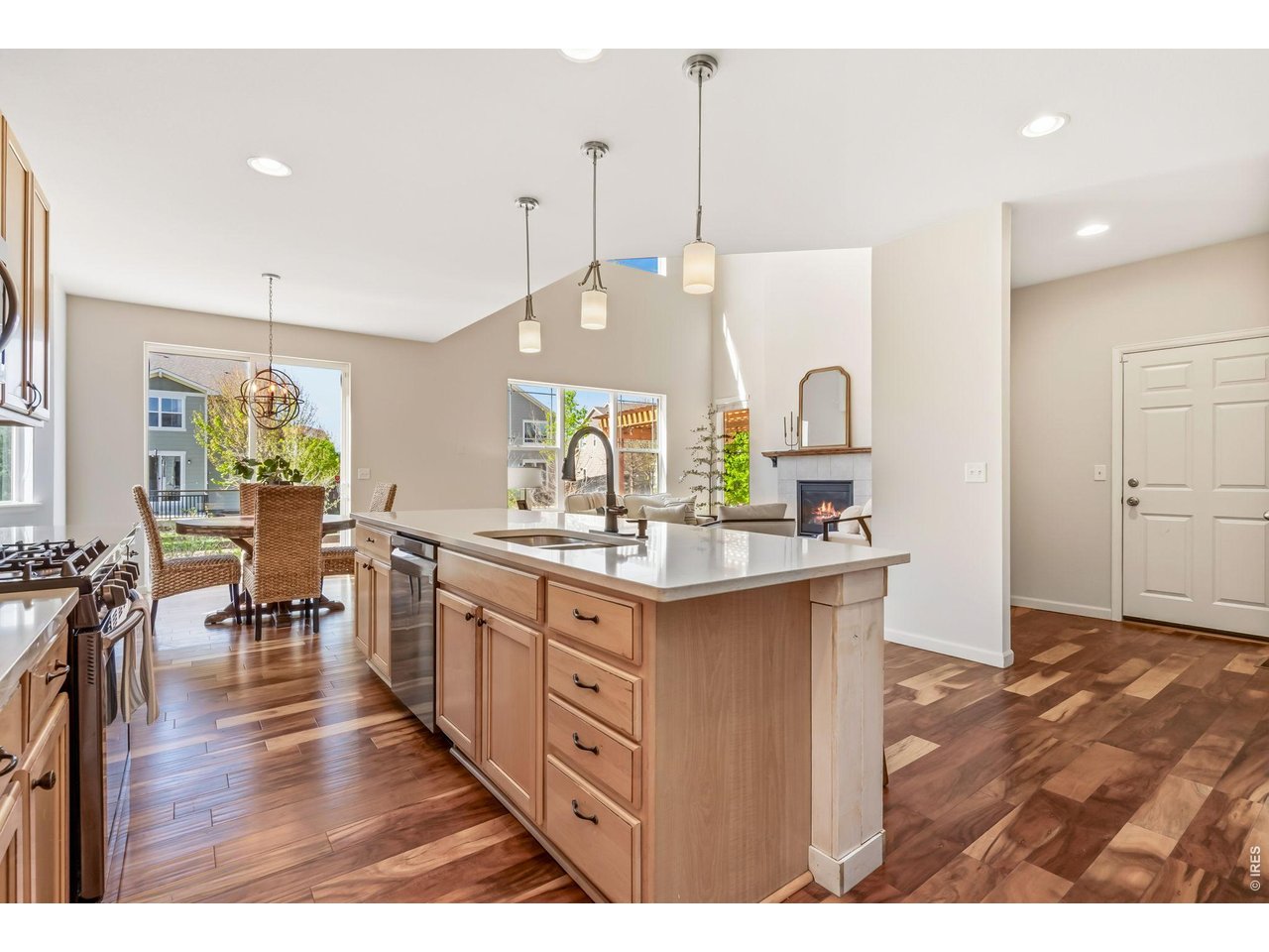 6759 Rainier Road Timnath, CO 80547 - Photo 5 of 30 a kitchen with stainless steel appliances granite countertop a stove a sink a oven a dining table with wooden floor