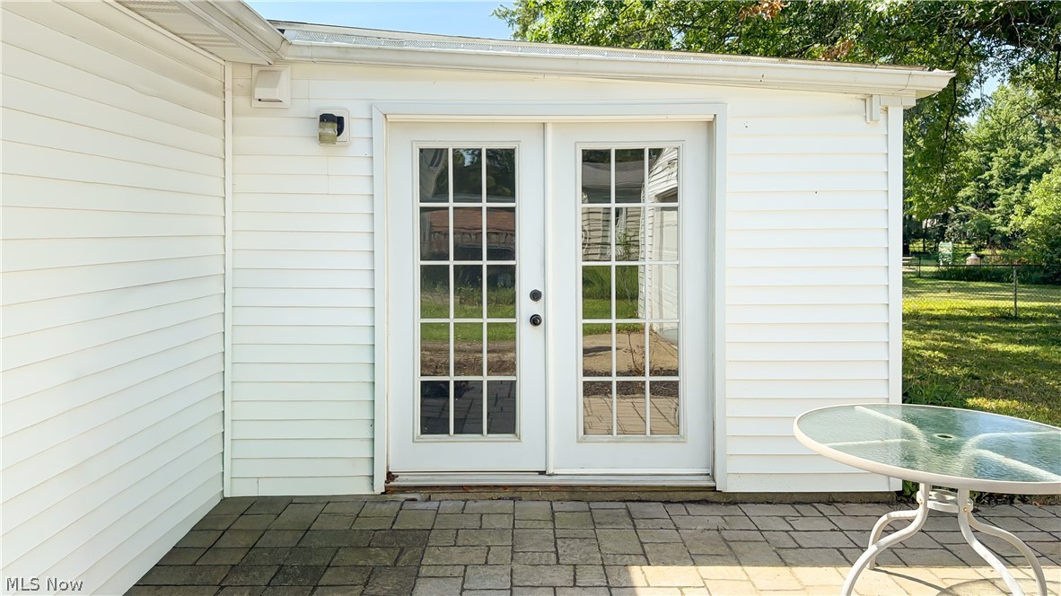 3796 North Santom Road Stow, OH 44224 - Photo 19 of 30 White horizontal siding exterior featuring double French doors with grid-patterned glass panels that leads to dining area