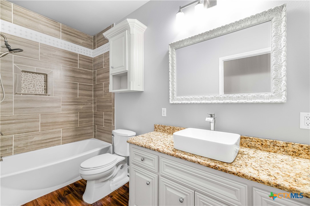 204 James Street Inez, TX 77968 - Photo 23 of 35 a bathroom with a granite countertop sink mirror vanity bathtub and toilet