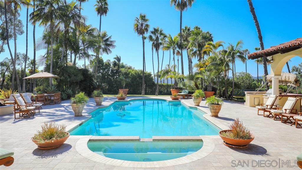 16556 Los Barbos Rancho Santa Fe, CA 92067 - Photo 18 of 22 a view of a swimming pool with a lounge chair and palm trees