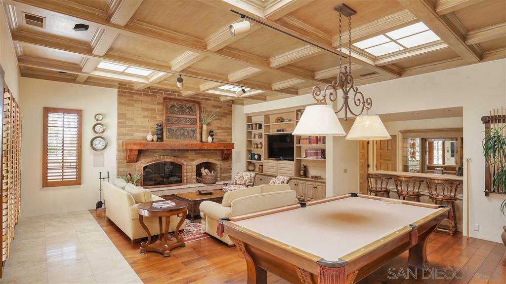 16556 Los Barbos Rancho Santa Fe, CA 92067 - Photo 8 of 22 a living room with furniture a fireplace and a chandelier
