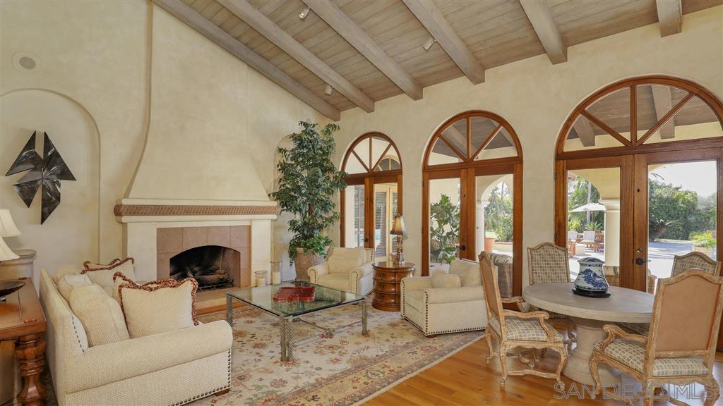 16556 Los Barbos Rancho Santa Fe, CA 92067 - Photo 10 of 22 a living room with furniture a fireplace and a floor to ceiling window