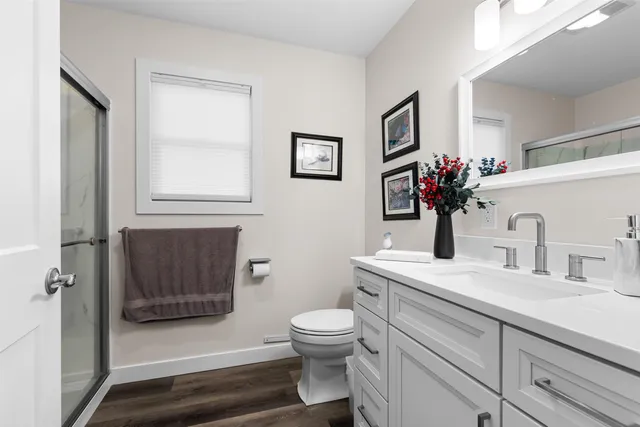 a bathroom with a sink a toilet and shower