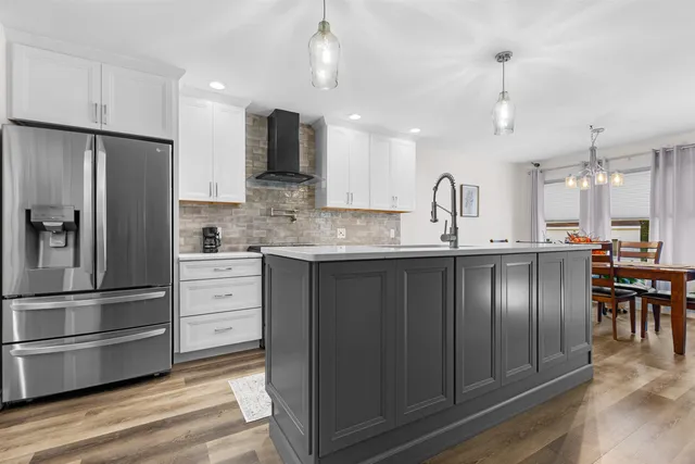 a kitchen with stainless steel appliances kitchen island granite countertop a refrigerator a stove a sink and a microwave