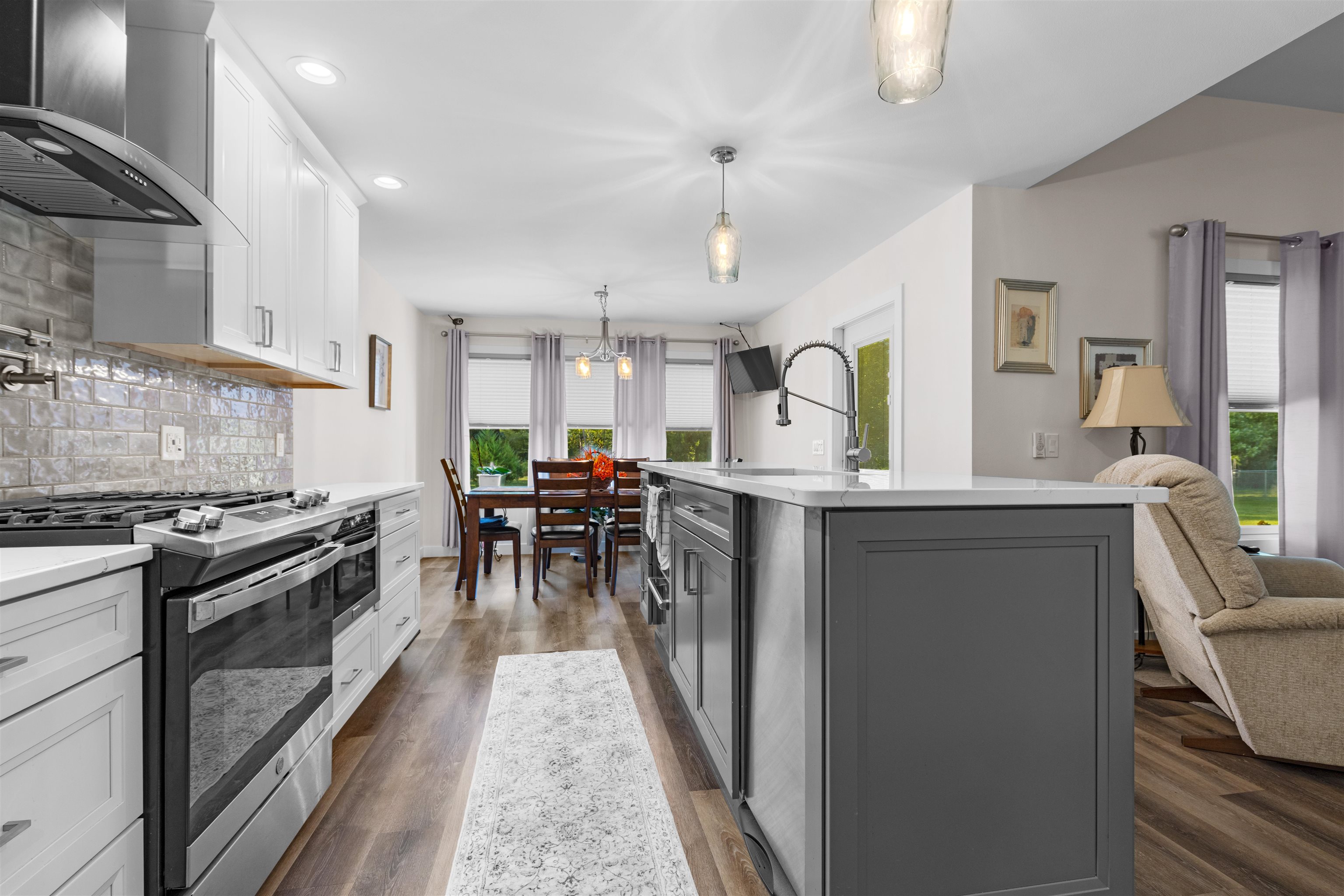 113 Taylor Lane Thomson, IL 61285 - Photo 7 of 29 a kitchen with stainless steel appliances kitchen island granite countertop a stove a sink a dining table and chairs with wooden floor