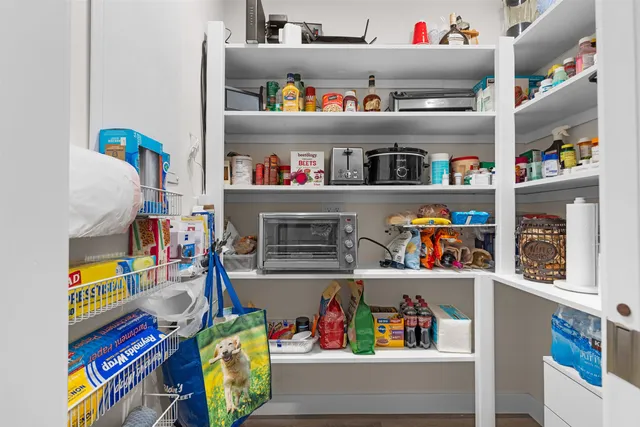 a utility room with fridge and a bed