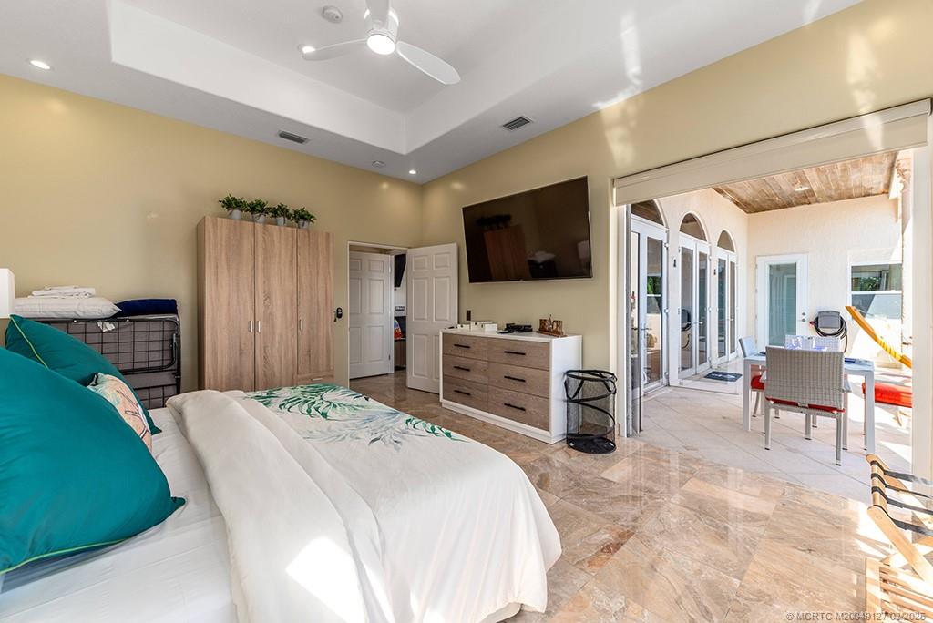 1981 Northeast Ocean Boulevard Stuart, FL 34996 - Photo 32 of 51 a bedroom with furniture a flat screen tv and a refrigerator