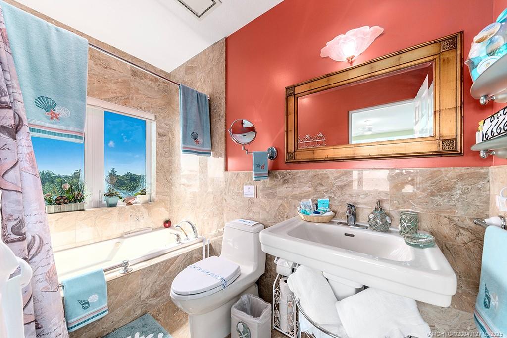 1981 Northeast Ocean Boulevard Stuart, FL 34996 - Photo 36 of 51 a bathroom with a sink vanity mirror and toilet