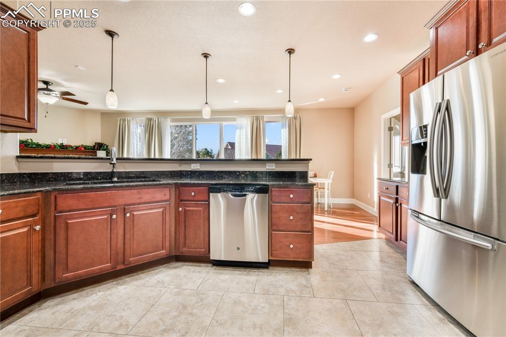 10484 Mile Post Loop Fountain, CO 80817 - Photo 17 of 50 a kitchen with stainless steel appliances granite countertop a sink a stove and a refrigerator
