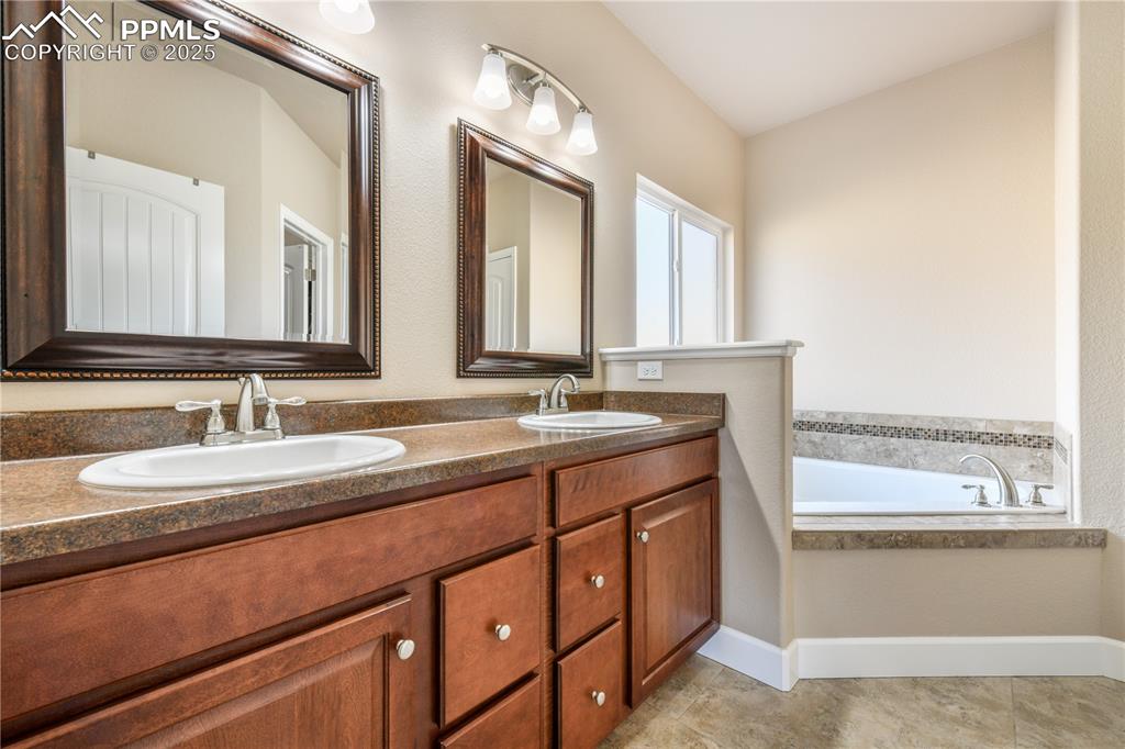 10484 Mile Post Loop Fountain, CO 80817 - Photo 22 of 50 a bathroom with a granite countertop sink and a large mirror