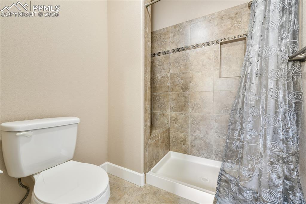 10484 Mile Post Loop Fountain, CO 80817 - Photo 24 of 50 a white toilet sitting next to a bath tub and shower