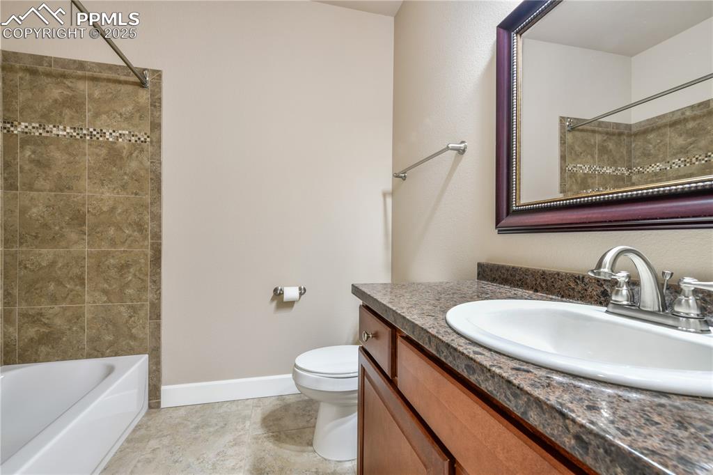 10484 Mile Post Loop Fountain, CO 80817 - Photo 27 of 50 a bathroom with a granite countertop sink a toilet and bathtub