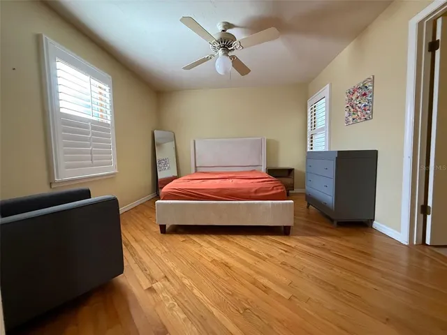 a bedroom with a bed and wooden floor