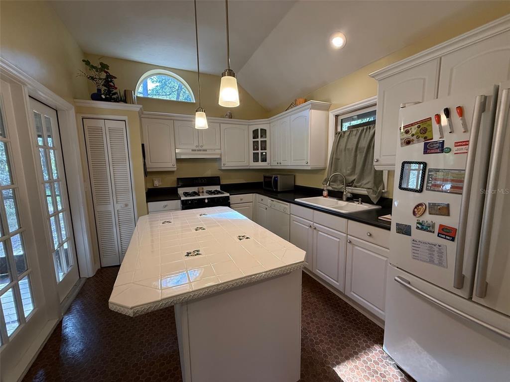 5601 Southwest 83 Drive Gainesville, FL 32608 - Photo 7 of 21 a kitchen with stainless steel appliances a stove a refrigerator a sink and white cabinets