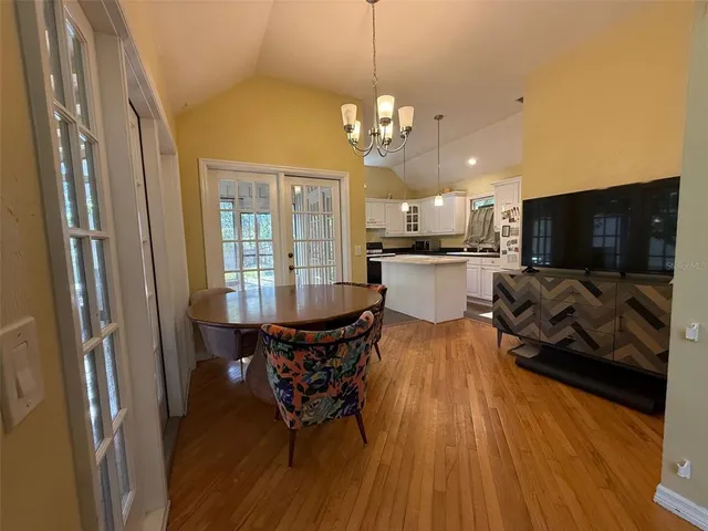 a kitchen with stainless steel appliances a dining table chairs stove and refrigerator