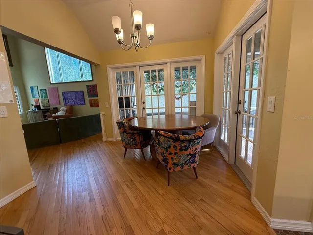 a view of a dining room with furniture a chandelier and wooden floor