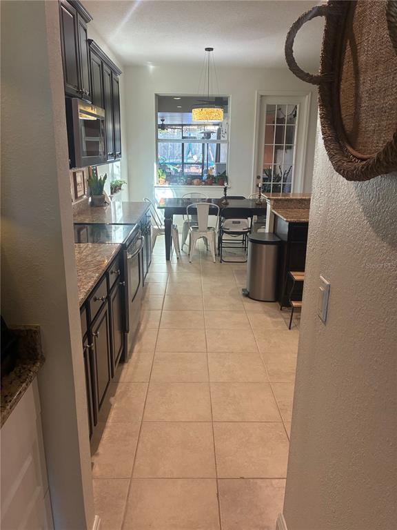 960 Seburn Road Apopka, FL 32703 - Photo 4 of 13 a kitchen with granite countertop a stove a sink a window and a dining table