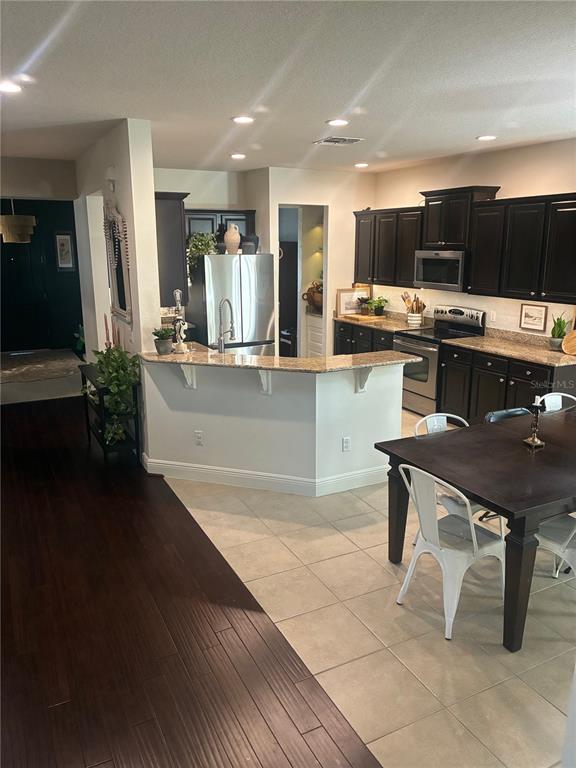 960 Seburn Road Apopka, FL 32703 - Photo 5 of 13 a kitchen with kitchen island stainless steel appliances a sink cabinets and wooden floor