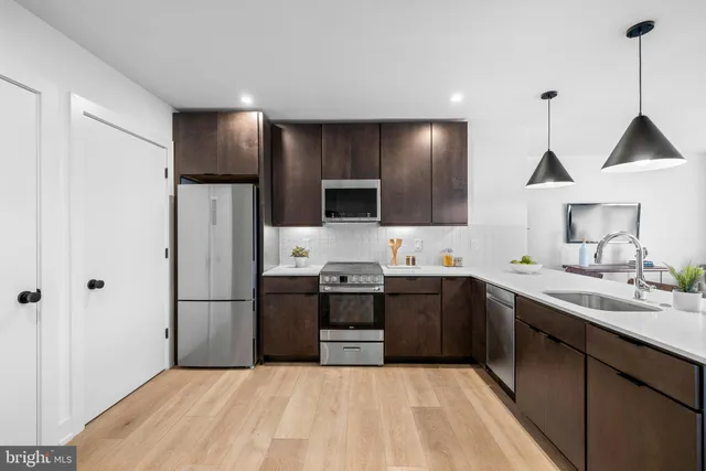 a large kitchen with a sink and stainless steel appliances