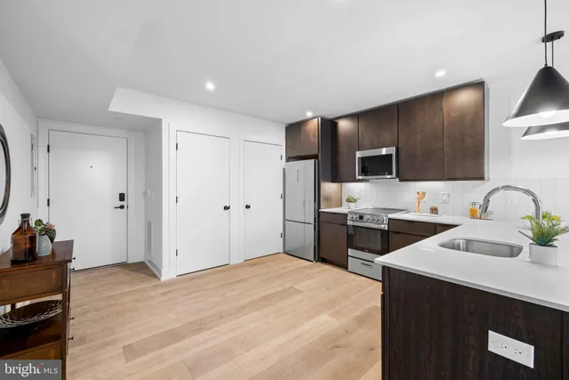a kitchen with stainless steel appliances a stove refrigerator sink and cabinets