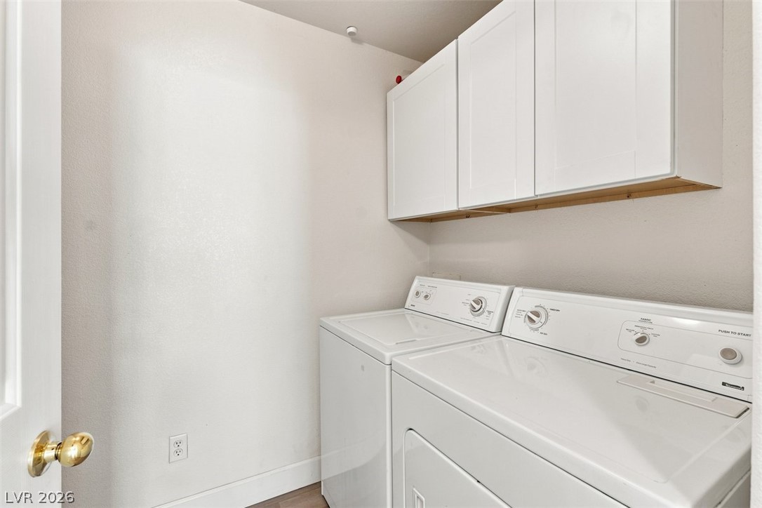 505 Rafkin Place Henderson, NV 89052 - Photo 33 of 35 Functional laundry room equipped with upper cabinetry and a washer/dryer set.