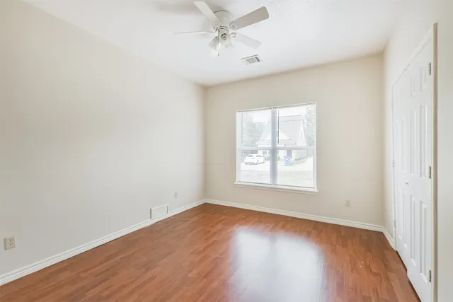 an empty room with a window and wooden floor