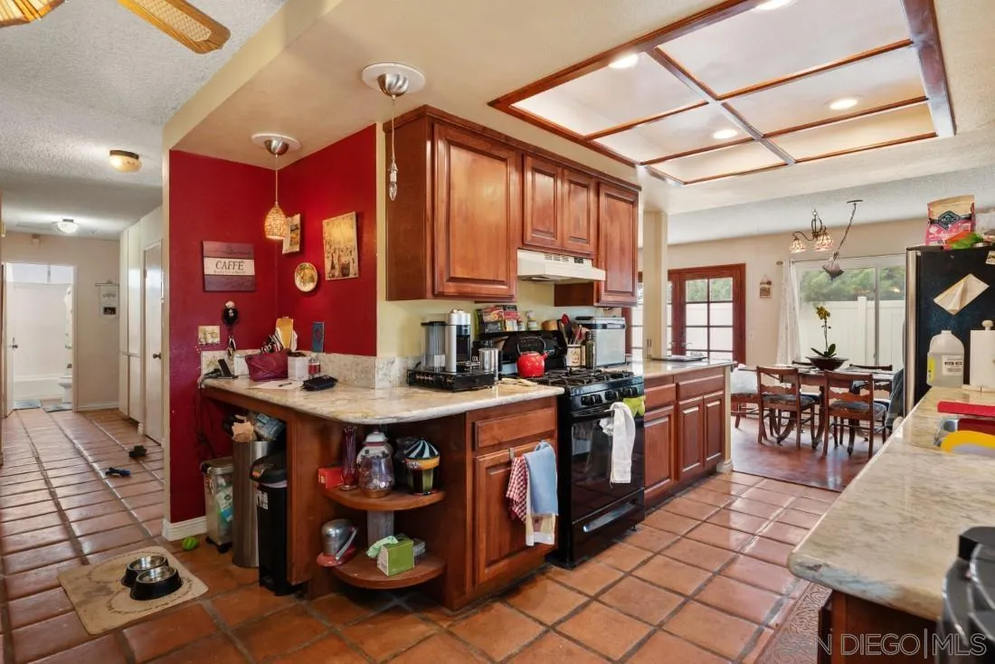 894 Coldstream Drive El Cajon, CA 92020 - Photo 12 of 30 a kitchen with stainless steel appliances granite countertop a stove a sink dishwasher and a dining table with the front door