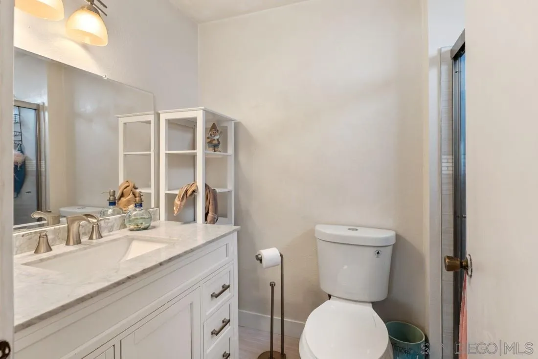 894 Coldstream Drive El Cajon, CA 92020 - Photo 23 of 30 a bathroom with a granite countertop toilet sink and mirror