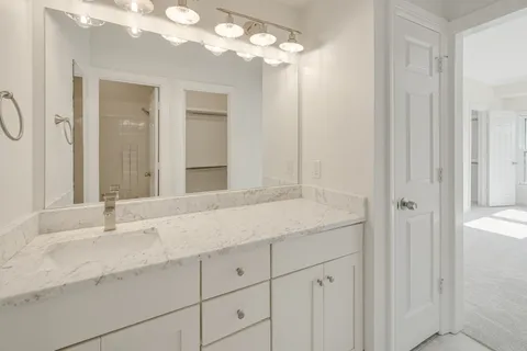 a bathroom with a granite countertop toilet and sink