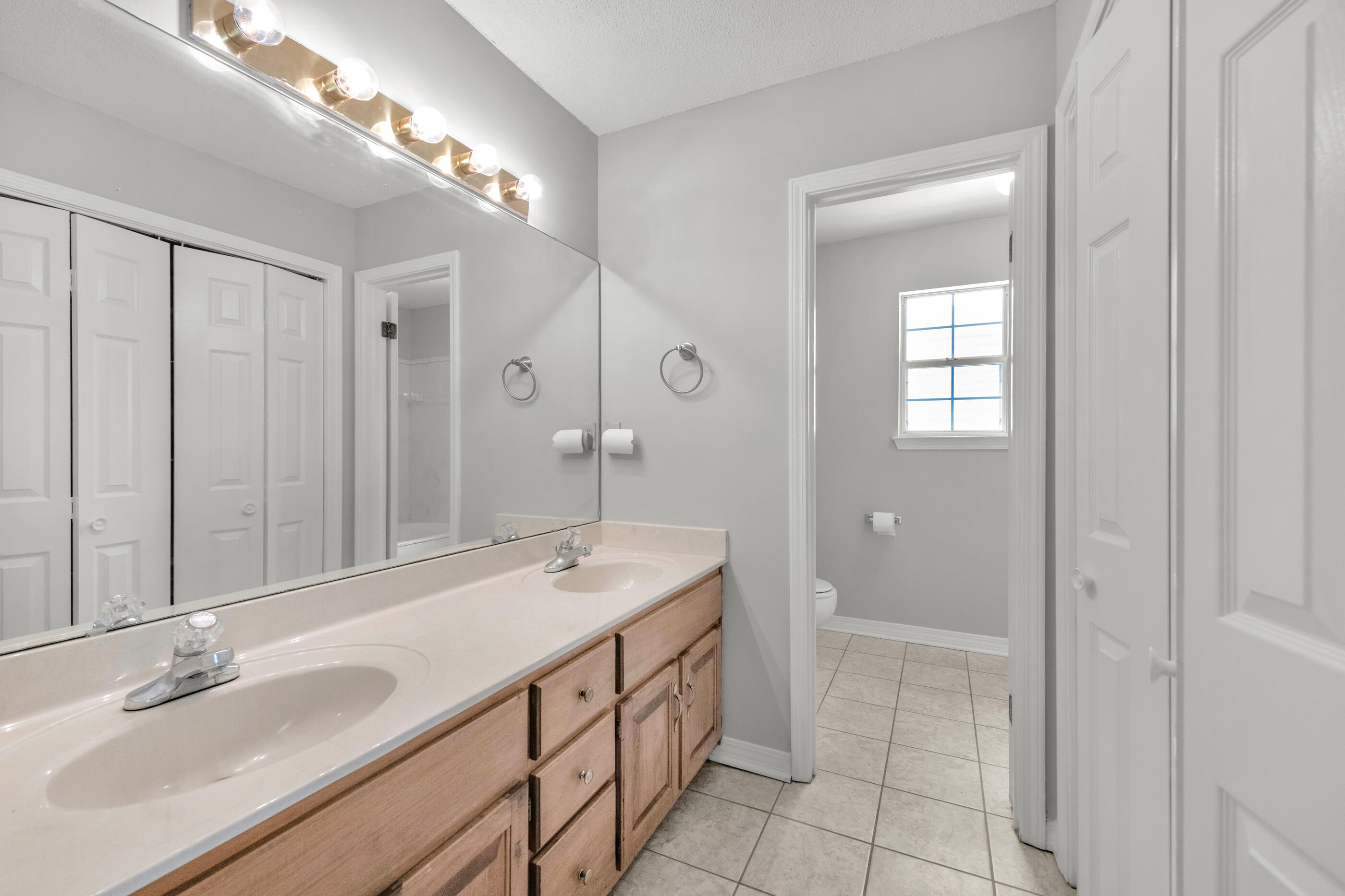 120 Wright Circle Niceville, FL 32578 - Photo 11 of 19 a bathroom with a double vanity sink a large mirror and a shower