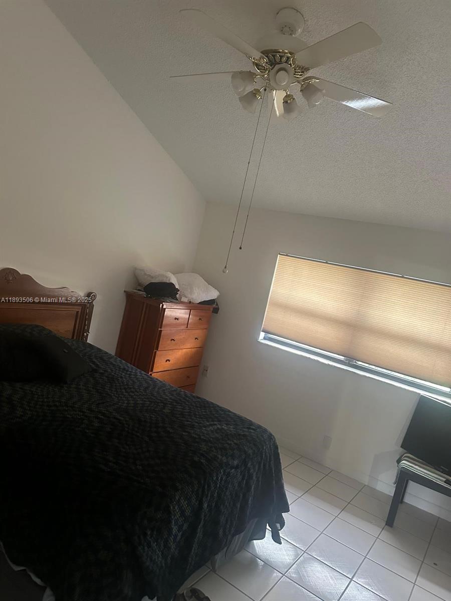 8000 Southwest 152nd Avenue, Unit 115 Miami, FL 33193 - Photo 22 of 33 a bedroom with a bed and a ceiling fan