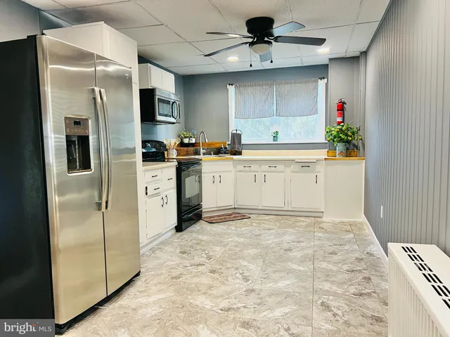 a kitchen with stainless steel appliances a refrigerator sink and microwave