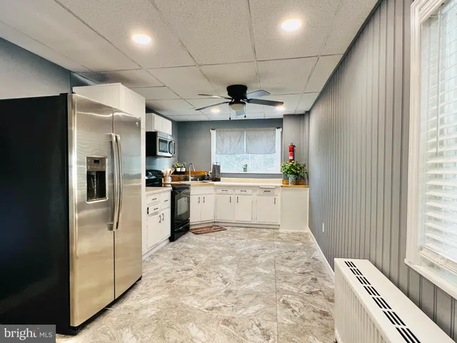 a kitchen with refrigerator and cabinets