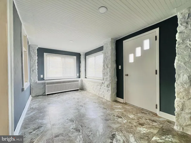 a view of an empty room with closet and mirror