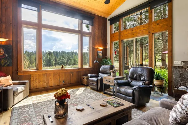 a living room with furniture and floor to ceiling windows