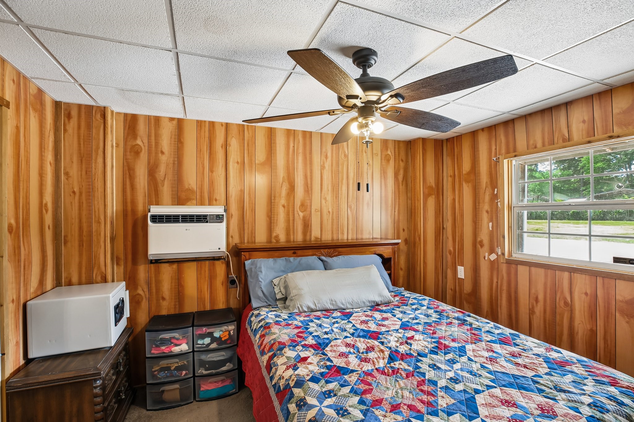 164 Frank Road Trinity, TX 75862 - Photo 3 of 20 The primary bedroom offers a warm, rustic atmosphere with classic wood-paneled walls and a cozy layout, perfect for a quiet escape at the end of the day.