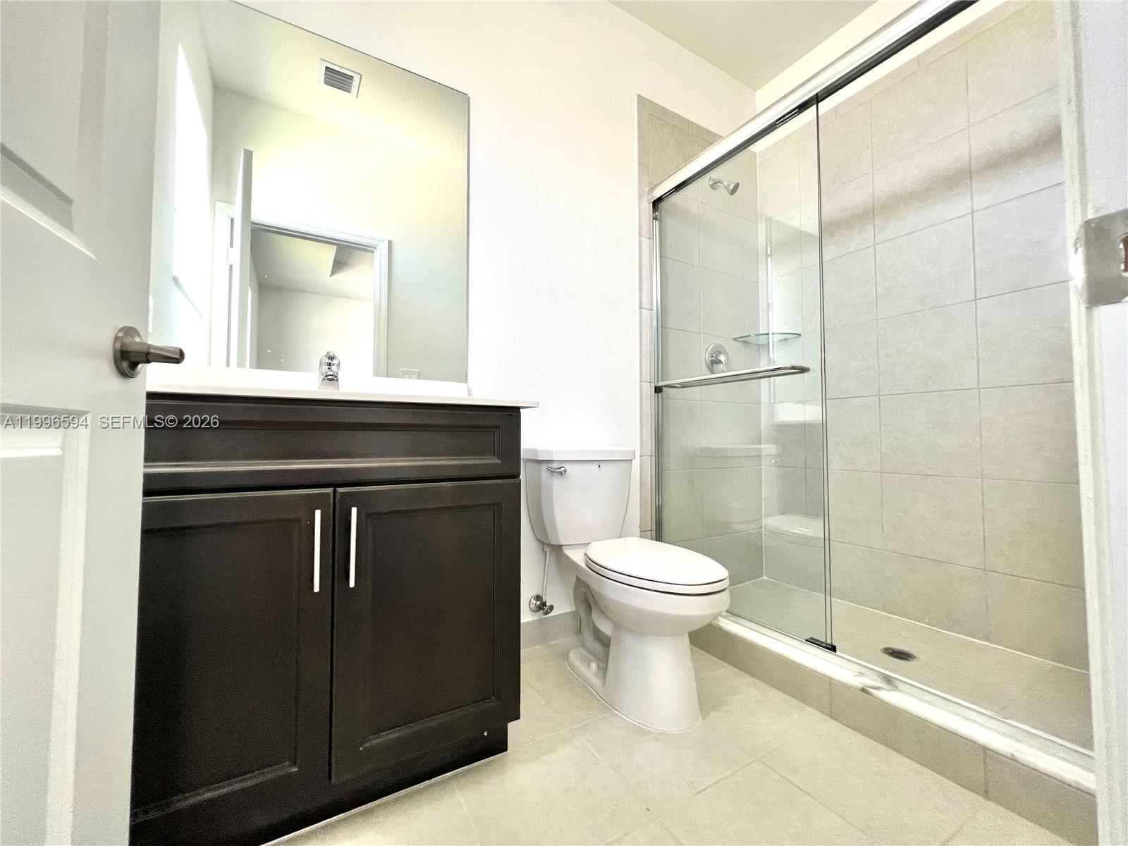 23373 Southwest 129th Path, Unit 23373 Homestead, FL 33032 - Photo 17 of 18 a bathroom with a sink a toilet and shower