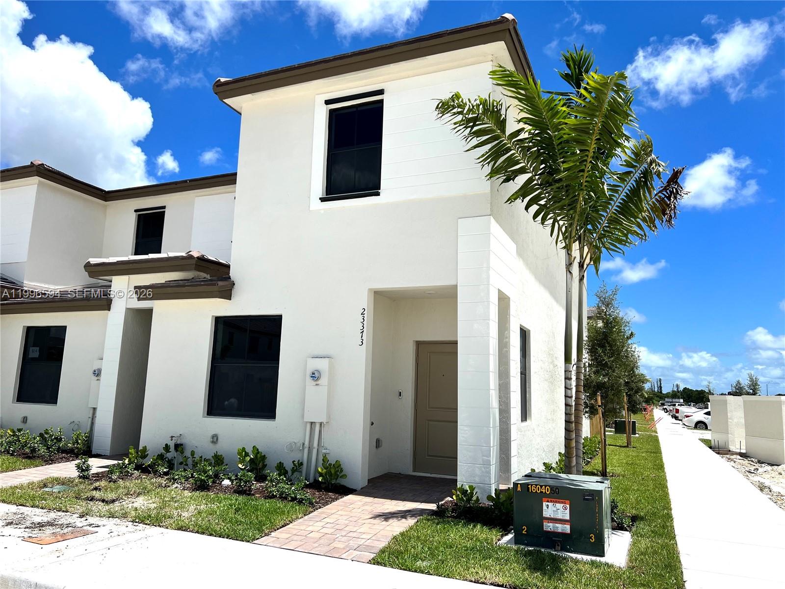 23373 Southwest 129th Path, Unit 23373 Homestead, FL 33032 - Photo 2 of 18 a front view of a house with garden