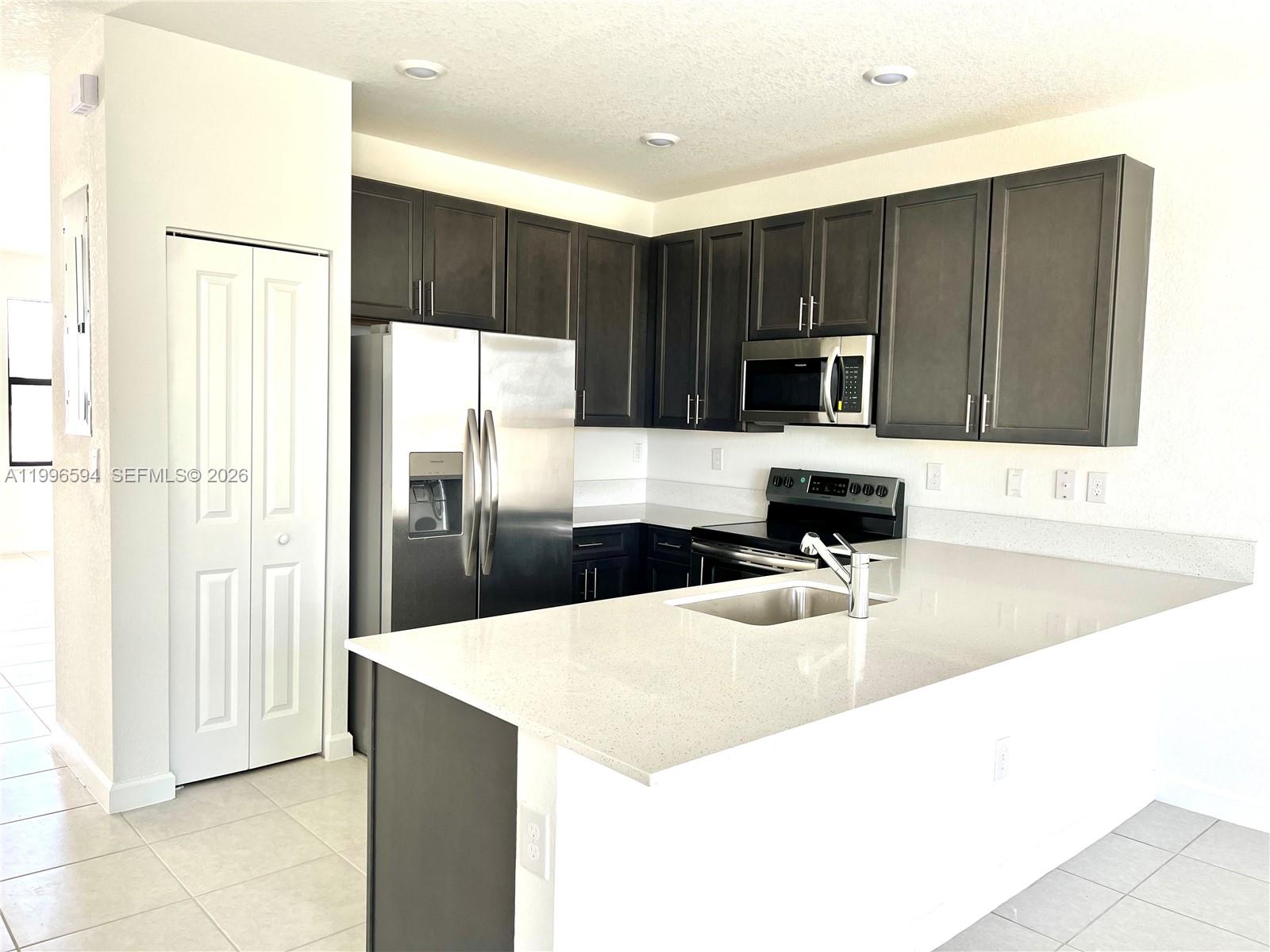23373 Southwest 129th Path, Unit 23373 Homestead, FL 33032 - Photo 7 of 18 a kitchen with kitchen island a counter top space cabinets and stainless steel appliances