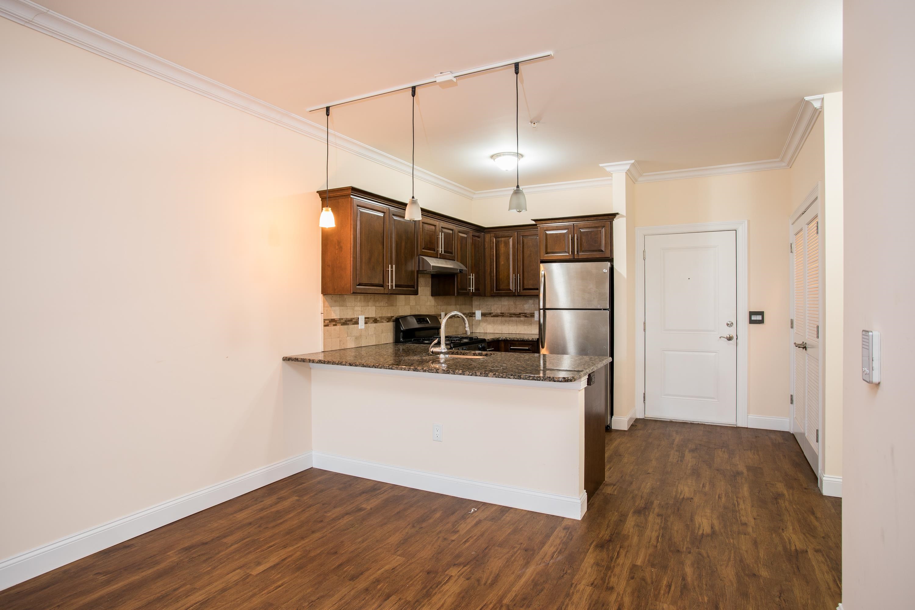 6111 Fillmore Place, Unit 306 West New York, NJ 07093 - Photo 18 of 27 a kitchen with stainless steel appliances a refrigerator a sink dishwasher a stove and white cabinets with wooden floor