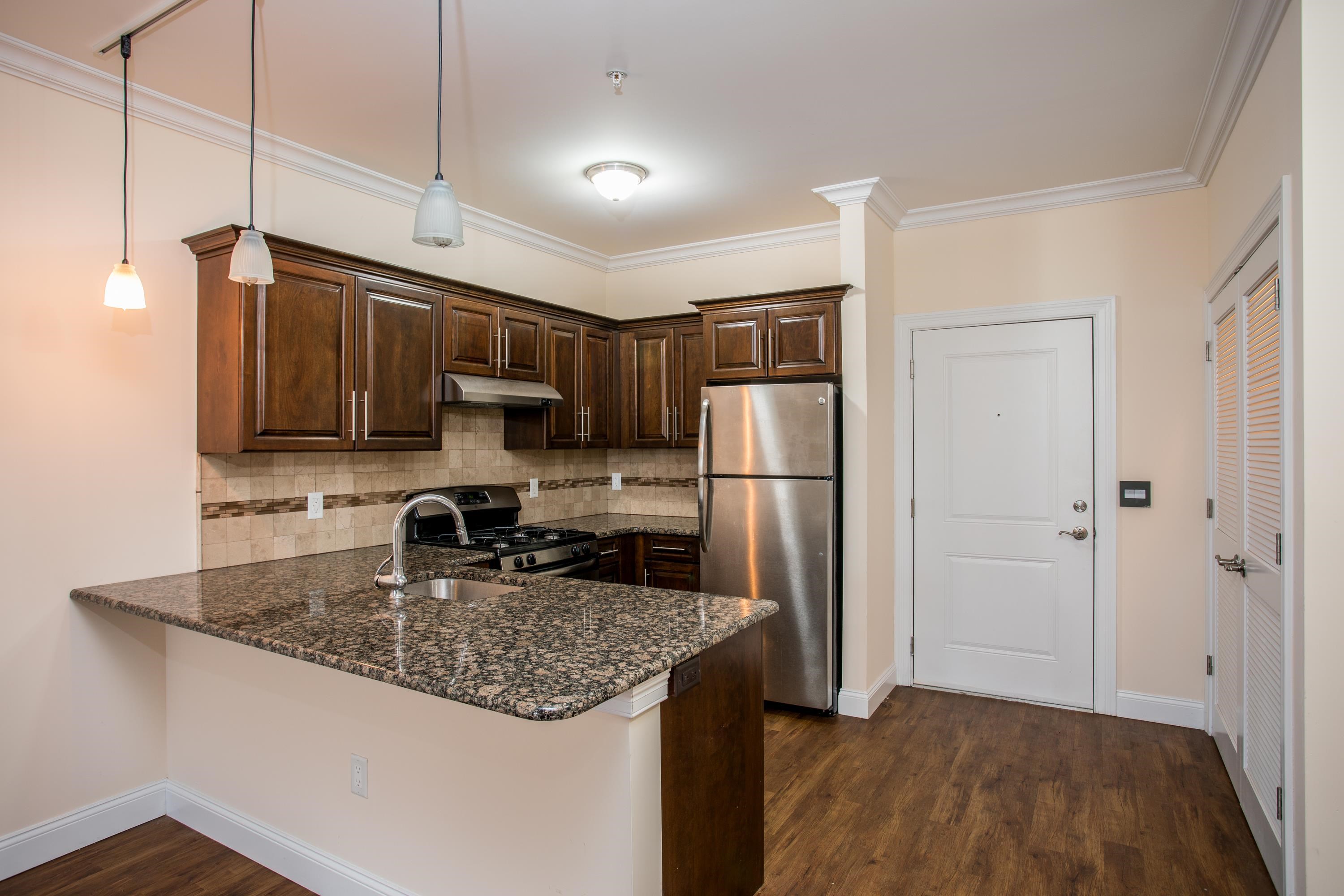 6111 Fillmore Place, Unit 306 West New York, NJ 07093 - Photo 21 of 27 a kitchen with kitchen island granite countertop stainless steel appliances a refrigerator a sink a stove a microwave and island
