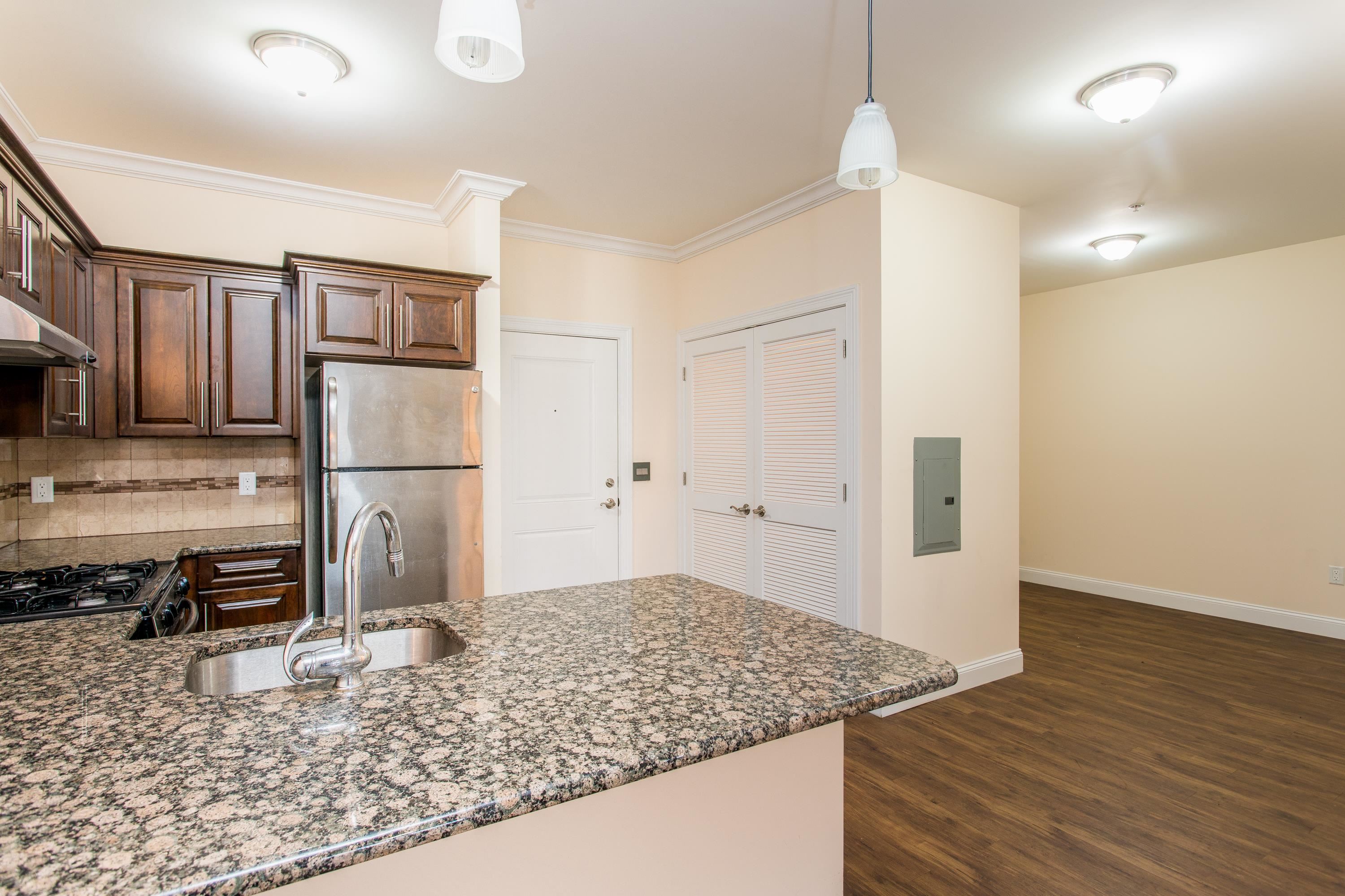 6111 Fillmore Place, Unit 306 West New York, NJ 07093 - Photo 22 of 27 a kitchen with kitchen island granite countertop a refrigerator and a stove top oven