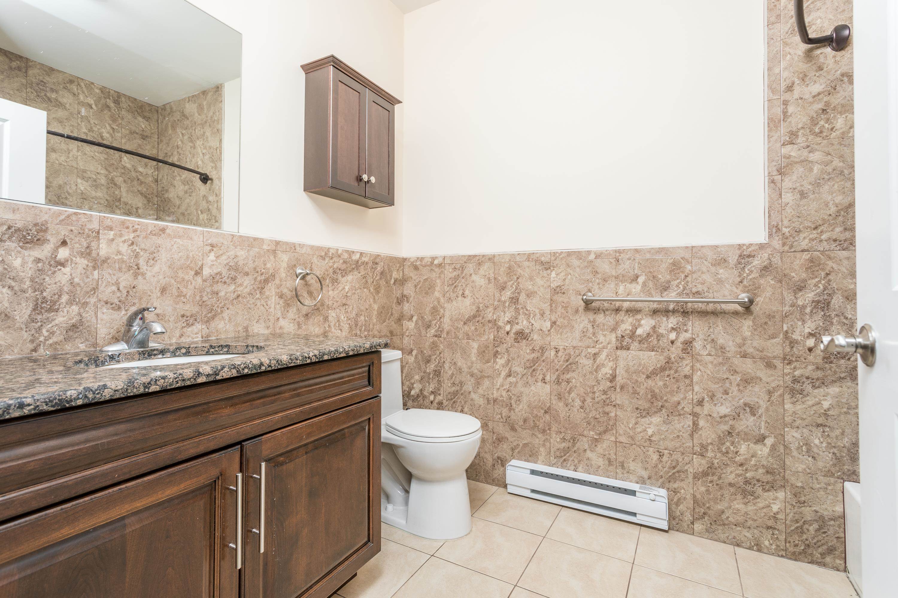 6111 Fillmore Place, Unit 306 West New York, NJ 07093 - Photo 6 of 27 a bathroom with a granite countertop sink and a toilet