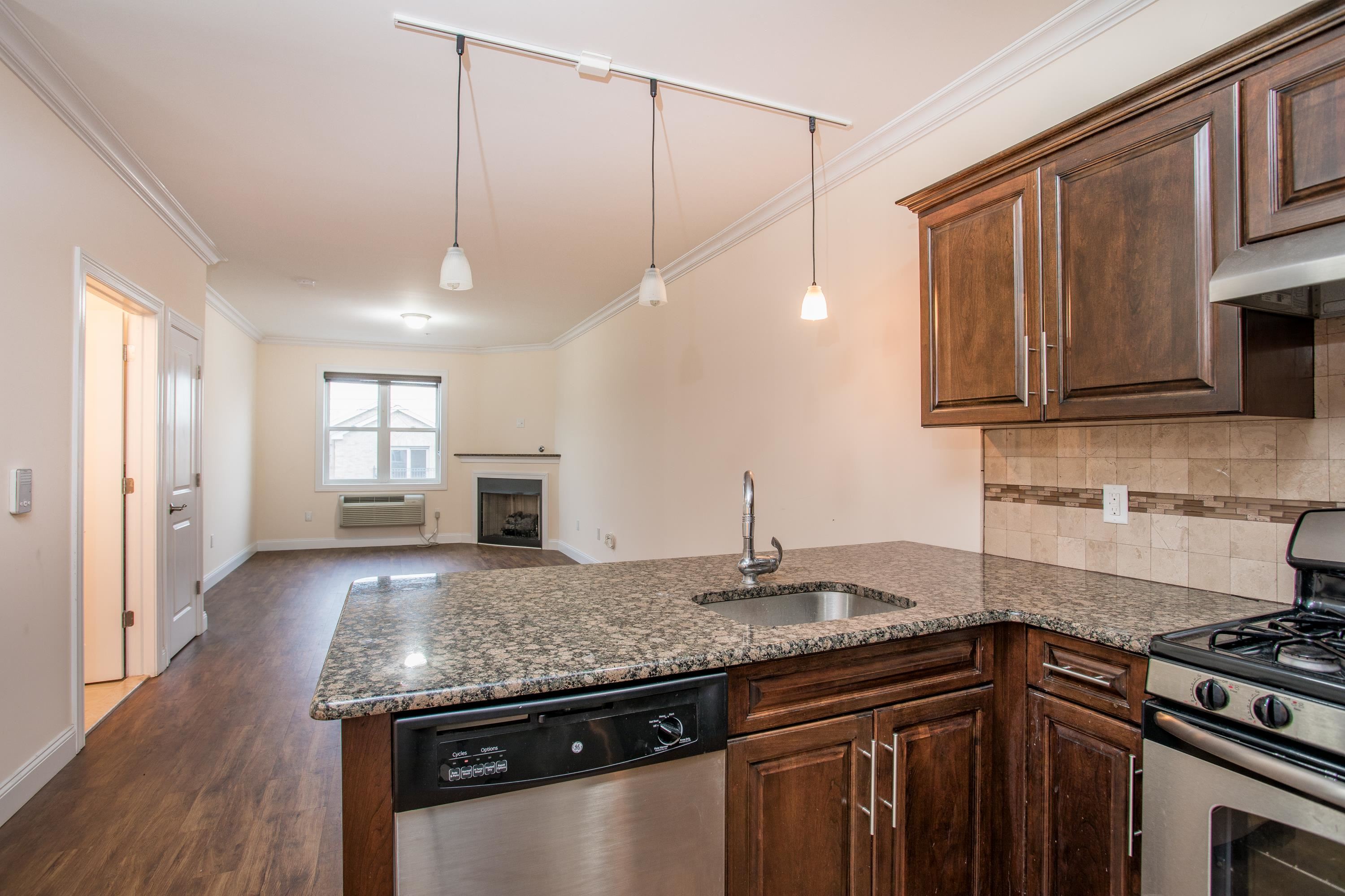 6111 Fillmore Place, Unit 306 West New York, NJ 07093 - Photo 8 of 27 a kitchen with granite countertop a sink cabinets and stainless steel appliances